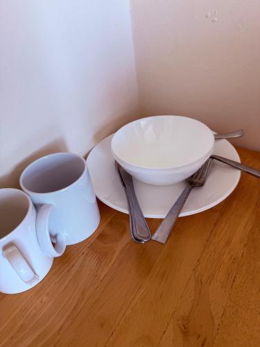 a white plate with a bowl and a cup of coffee at Kirkar Flat in Penton Mewsey