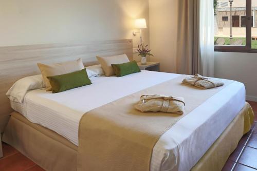 a bedroom with a large bed with two bags on it at Hotel Montepiedra 4''''sup in Playas de Orihuela