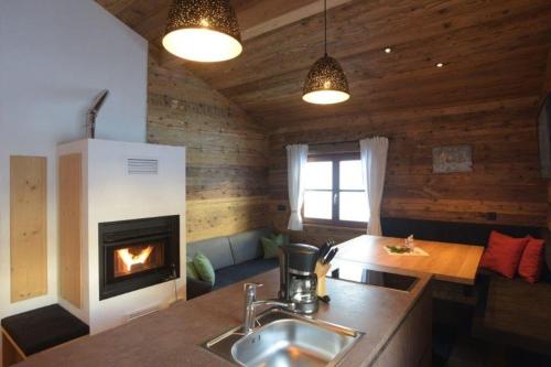 a kitchen with a fireplace in a log cabin at Ausserhof Hütte mit Sauna Südtirol in Riobianco