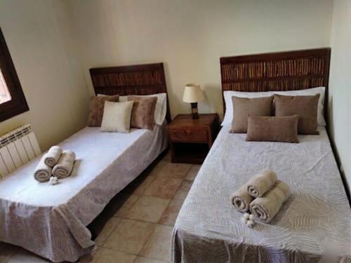 a bedroom with two beds with towels on them at Casa Rural en El Burguillo - Puerto Pez in Las Cruceras
