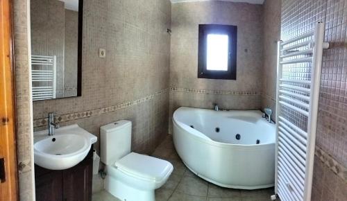 a bathroom with a tub and a toilet and a sink at Casa Rural en El Burguillo - Puerto Pez in Las Cruceras