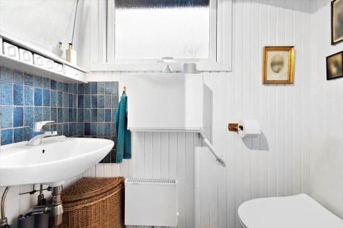 a white bathroom with a sink and a toilet at 8965-Allingabro-Hasselvej-3 in Skovgårde