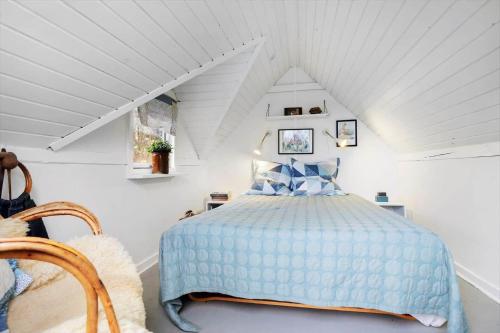 a bedroom with a blue bed in a attic at 8965-Allingabro-Hasselvej-3 in Skovgårde