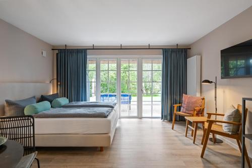 a bedroom with a bed and a sliding glass door at Beach Lodge Beach Lodge Appartement 6 in Böhl