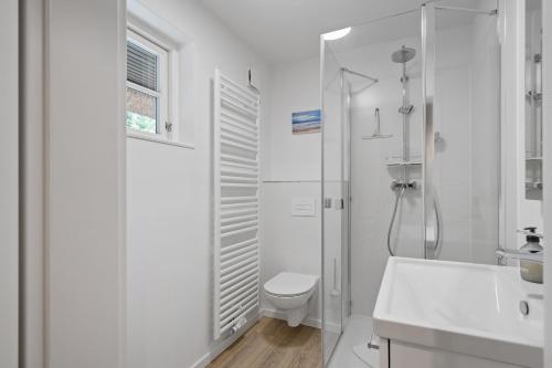 a white bathroom with a toilet and a shower at Beach Lodge Beach Lodge Appartement 6 in Böhl
