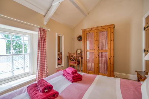 a bedroom with a large bed with pink towels on it at Delfryn in Tenby