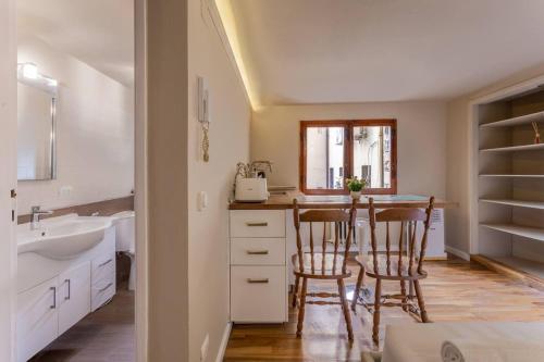 a kitchen with a sink and a table with chairs at Central Gucciardini house in Florence