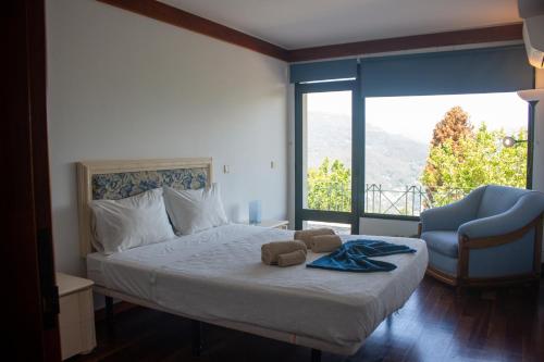 a bedroom with a bed with a chair and a window at Casa Martagão do Gerês by Gerês Casas in Caniçada
