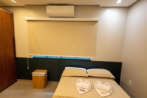 a bedroom with a bed with two heart shaped towels at Alter Casa Sawe, Alter do Chão, PA in Santarém
