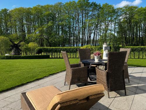 a patio with a table and chairs and a lawn at Ferienhaus Strandperle in Loddin