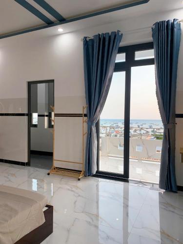 a bedroom with a bed and a large window at CoCo SEA in Mui Ne