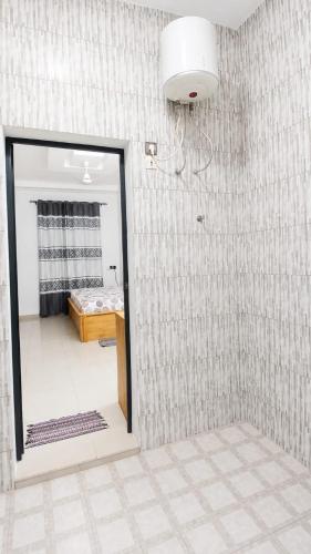 a bathroom with a mirror and a room with a bed at Grand Studio Meublé à Lomé in Komé