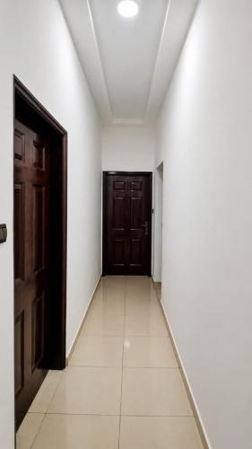 an empty hallway with brown doors and white floors at Grand Studio Meublé à Lomé in Komé