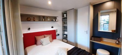 a small bedroom with a red headboard and a bed at Campeggio Internazionale Frassanito in Otranto