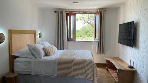a bedroom with a large bed and a window at Chalé Brisa do Rio in Paulino Neves
