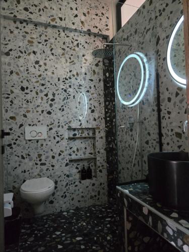 a bathroom with a toilet and two windows at Villa Mare Lux in Nea Fokea