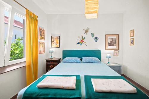 a bedroom with a blue bed with two pillows at Apartman Mafini in Krašići