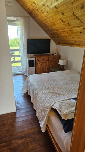 a bedroom with a bed and a large window at Zinnia Vendégház in Nagyrada