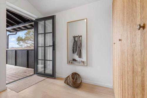 a living room with a mirror and a door at 8569-Grenaa-Kystvej-3-b in Grenå Strand