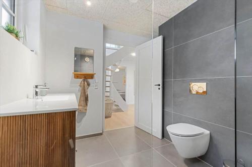 a bathroom with a toilet and a sink and a staircase at 8569-Grenaa-Kystvej-3-b in Grenå Strand