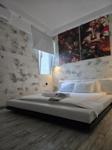 a bedroom with a large bed with a painting on the wall at Villa Mare Lux in Nea Fokea