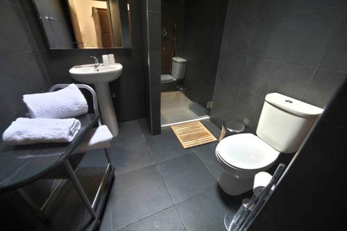 a bathroom with a white toilet and a sink at Quinta da Boa Ventura in Bragança
