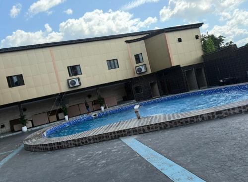 a large swimming pool in front of a building at Goldstep hotel Okpaka in Warri