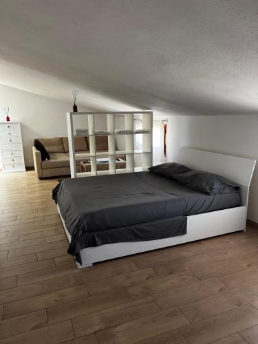 a bedroom with a large bed and a couch at Cuore Selargius in Selargius