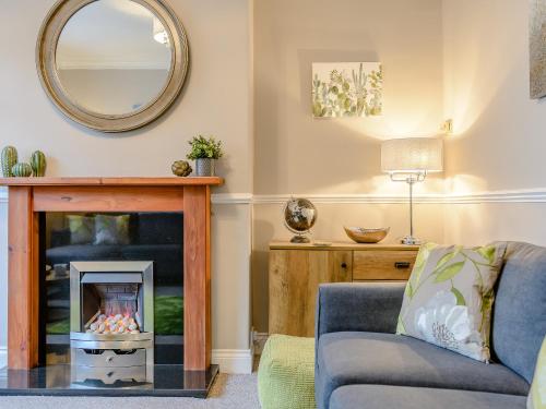 a living room with a fireplace and a mirror at High Haven in Amble