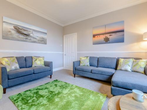 a living room with two blue couches and a table at High Haven in Amble