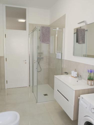 a white bathroom with a shower and a sink at Beautiful Home Mxp in Gallarate