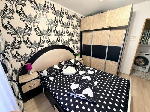 a bedroom with a black and white bed and a wall at Apartament Arys 2 in Neptun