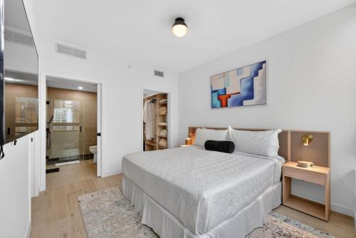 a white bedroom with a bed and a bathroom at Downtown Miami Luxe 1BR! in Miami