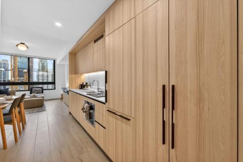 a kitchen with wooden cabinets and a dining room at Downtown Miami Luxe 1BR! in Miami