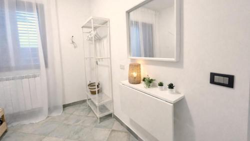a white bathroom with a sink and a mirror at CASA NICOLAS 158 by SalentoAffitti in Neviano