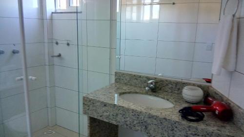 a bathroom with a sink and a shower at Hotel Silver Gold in Dois Vizinhos