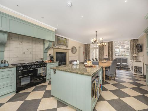 a kitchen with green cabinets and a table in it at Villa Abbotsford by Interhome in Darnick