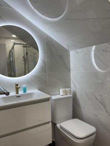 a bathroom with a toilet and a sink and a mirror at Boutique Princesa in Marbella