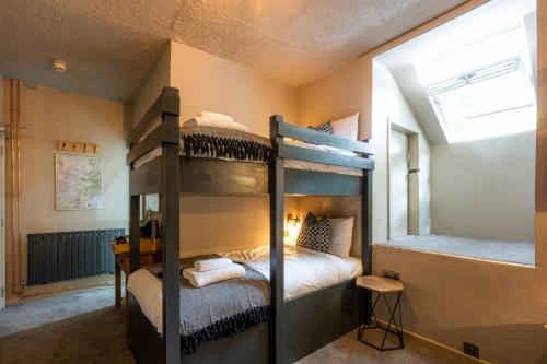 a bedroom with two bunk beds and a window at Tyn-y-Coed Inn in Betws-y-coed