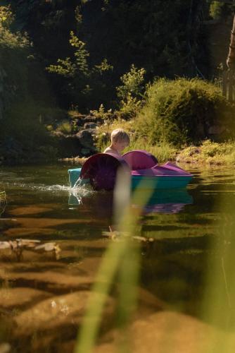 a boy is in a boat in the water at Alpin Family Resort Seetal in Kaltenbach