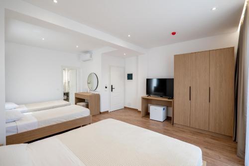 a living room with a bed and a tv at Vila 2M in Sarandë
