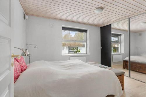 a bedroom with a large white bed and a window at 1670-Melby-Kragesvej-36 in Melby