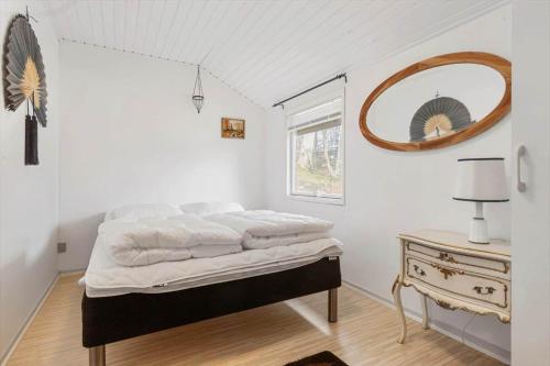 a white bedroom with a bed and a mirror at 8881-Glesborg-Benzonstien-27 in Fjellerup Strand