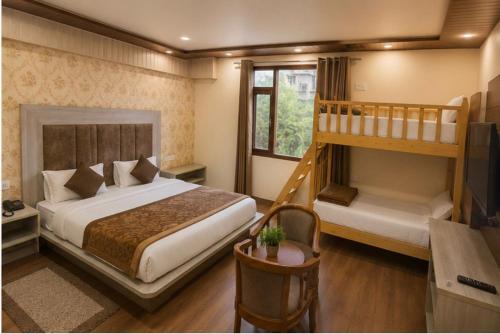 a bedroom with a bed and a bunk bed at YogMaya Regency in Shimla