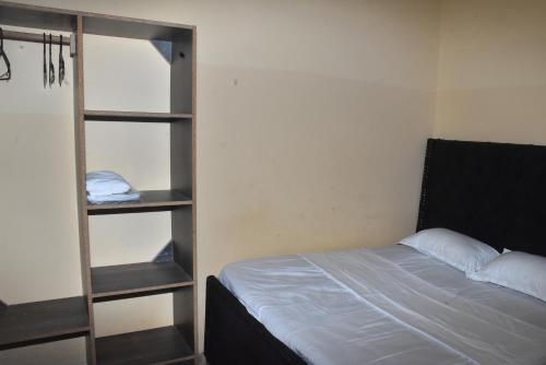 a bedroom with a bed and a book shelf at Maya Haven in Ukunda