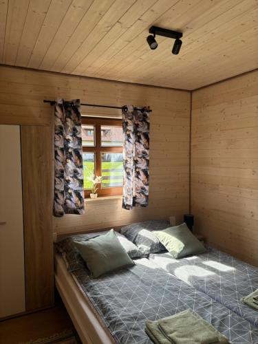 a room with a bed in a wooden cabin at Domki Stokrotka in Ruciane-Nida