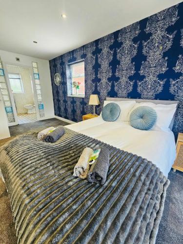 a bedroom with a large bed with blue walls at Luxury Home with Pool in Barnsley