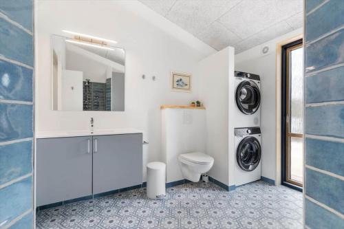 a bathroom with a toilet and a washer and dryer at 8882-Glesborg-Kaervejen-5 in Fjellerup Strand