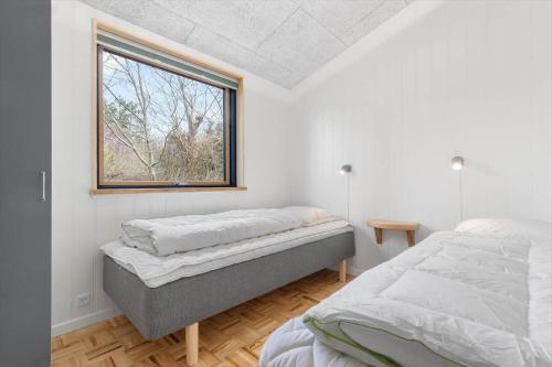 two beds in a room with a window at 8882-Glesborg-Kaervejen-5 in Fjellerup Strand
