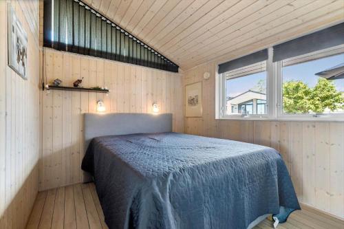 a bedroom with a bed in a room with a window at 84256-Ronde-Strandvejen-108 in Rønde